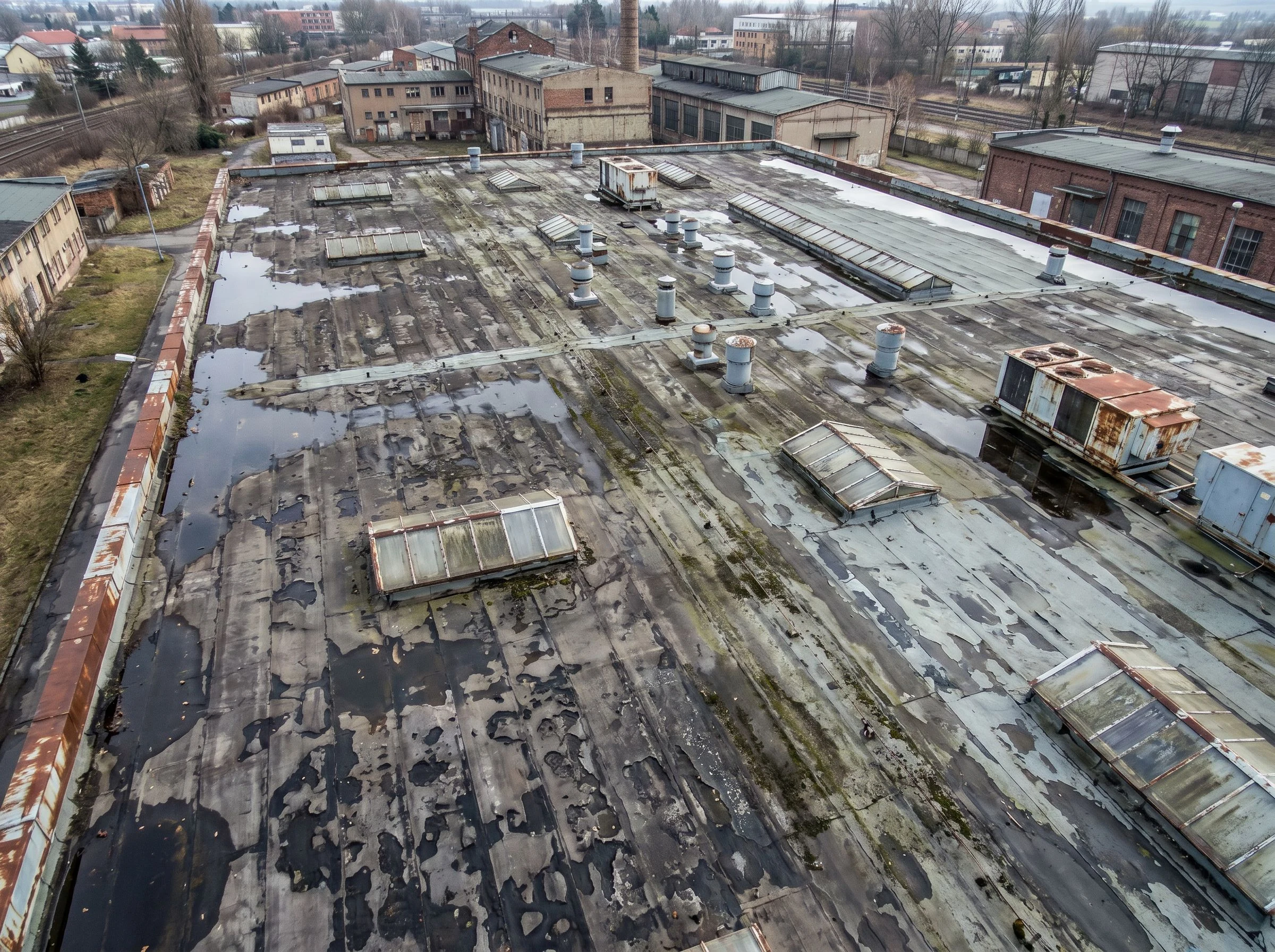 Industrie-Flachdach vor der Sanierung — marode, verwitterte Dachhaut